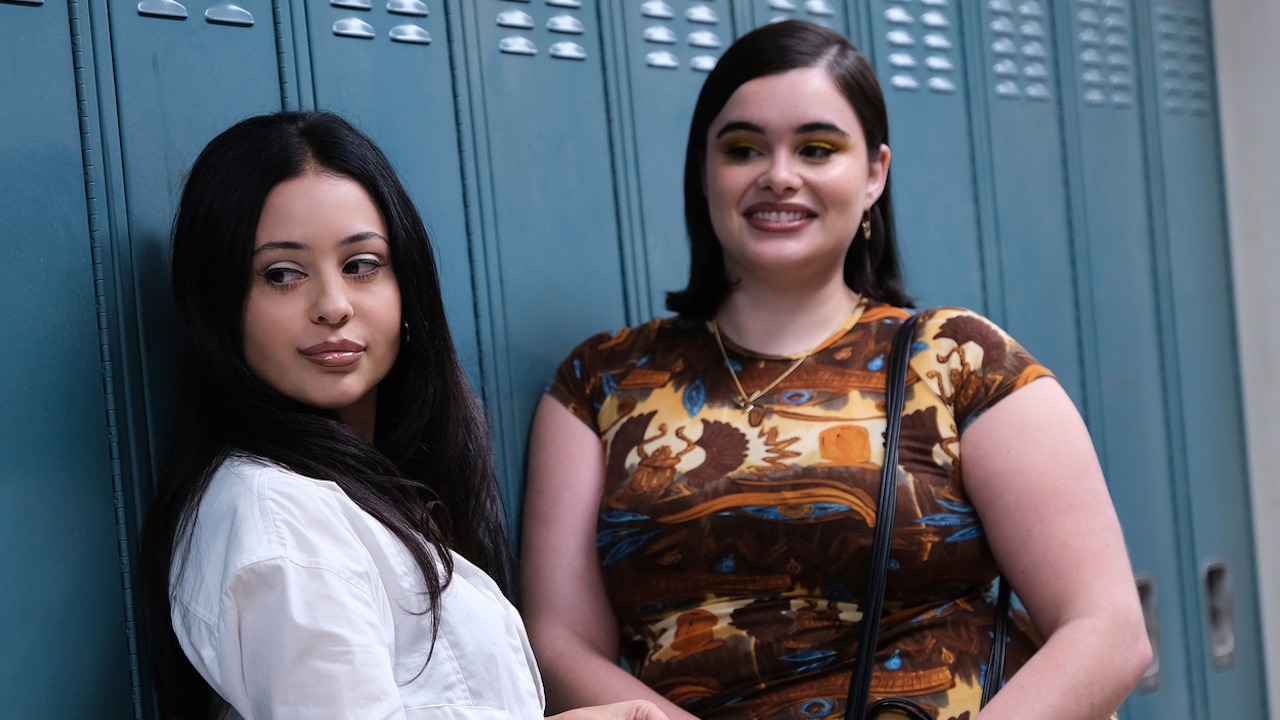 Alexa Demie and Barbie Ferreira smiling as they look over at someone off camera while standing next to blue lockers in Season 2, episode 7 of Euphoria