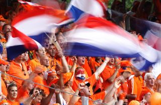 Netherlands fans, dressed in orange, wave flags during their team's 2006 World Cup clash against Portugal in Germany.