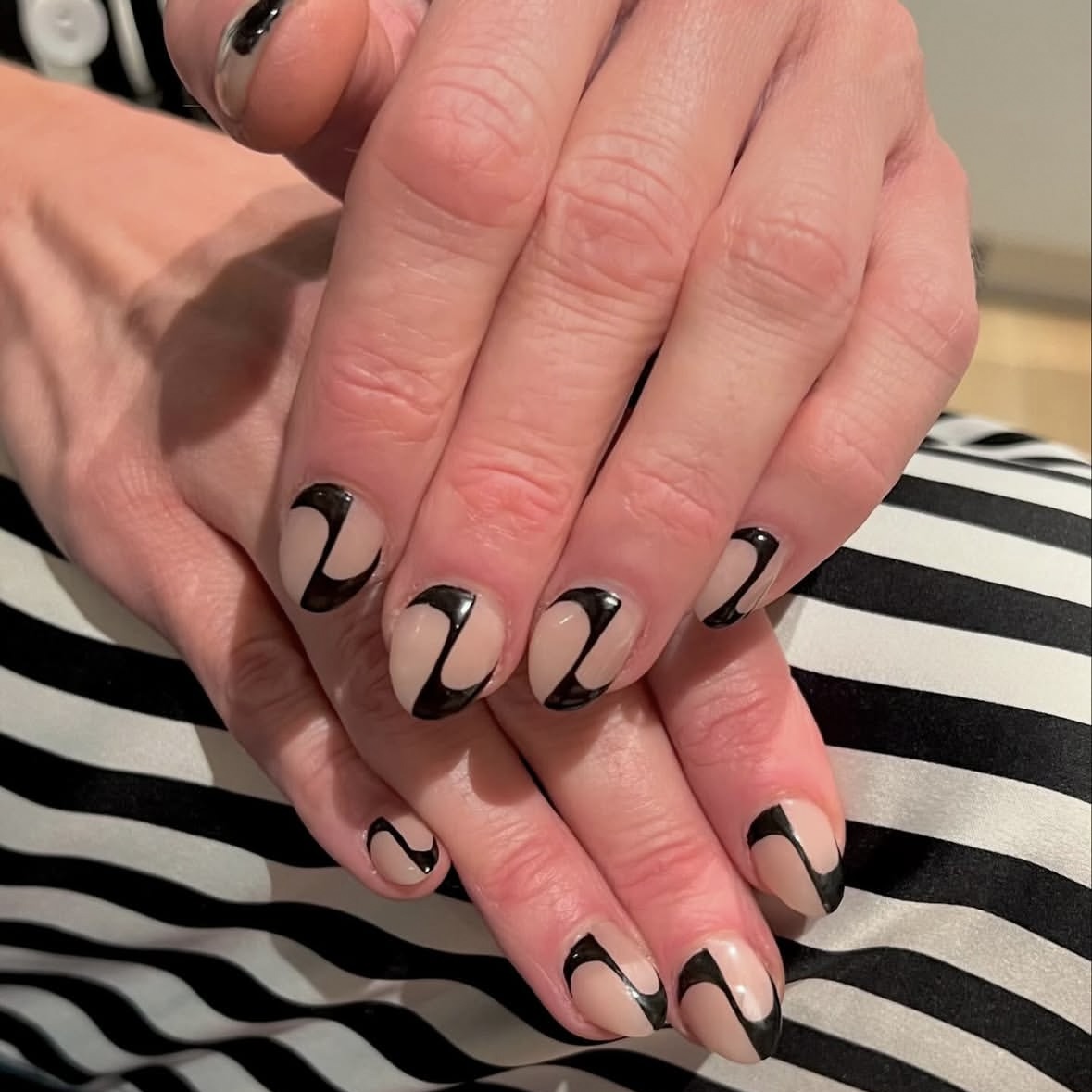 A short nude manicure with black detailing for a negative space effect.