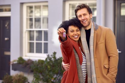 smiley couple holding house keys 