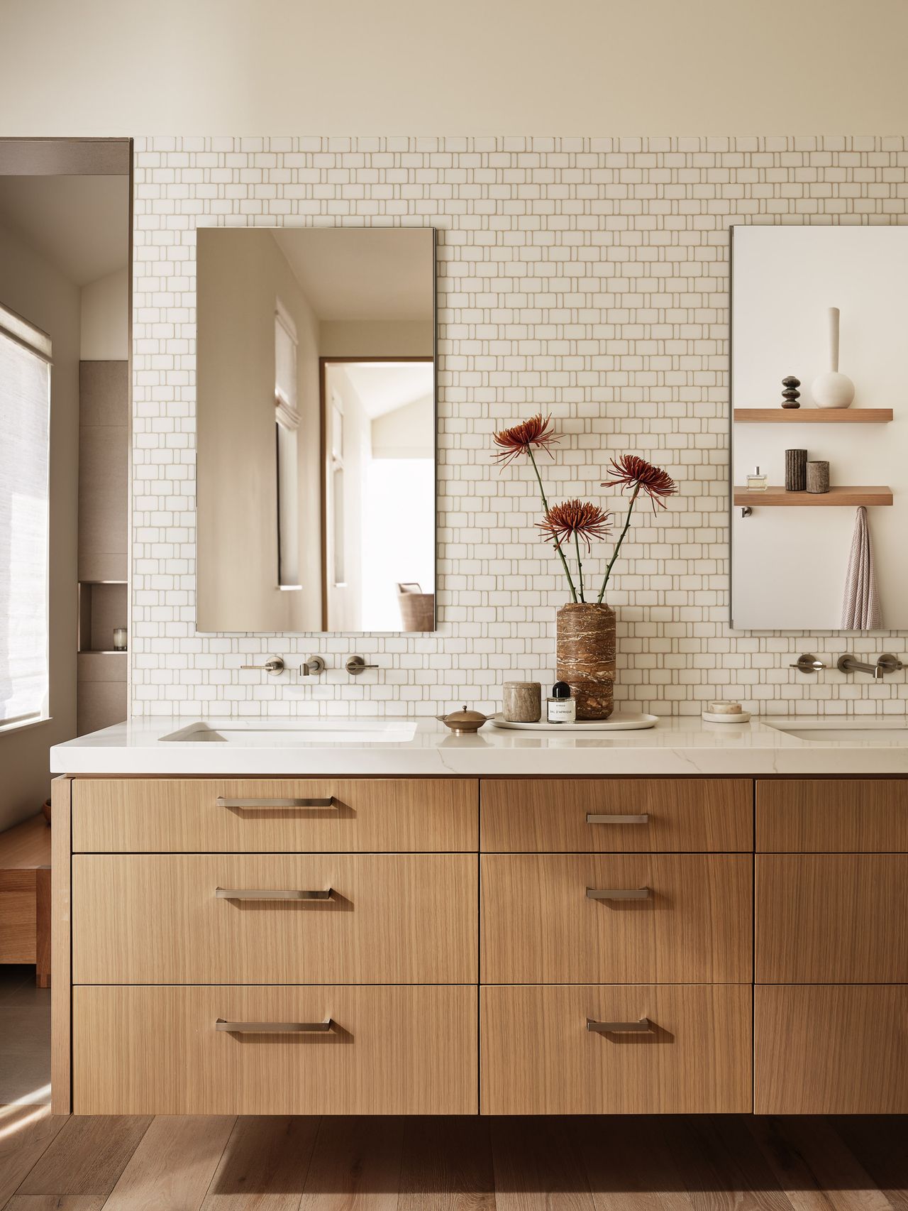 a primary bathroom with a mosaic patterned wall tile