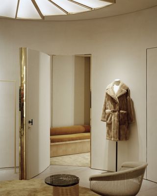 Fur coat on display in a room with white and bronze decor