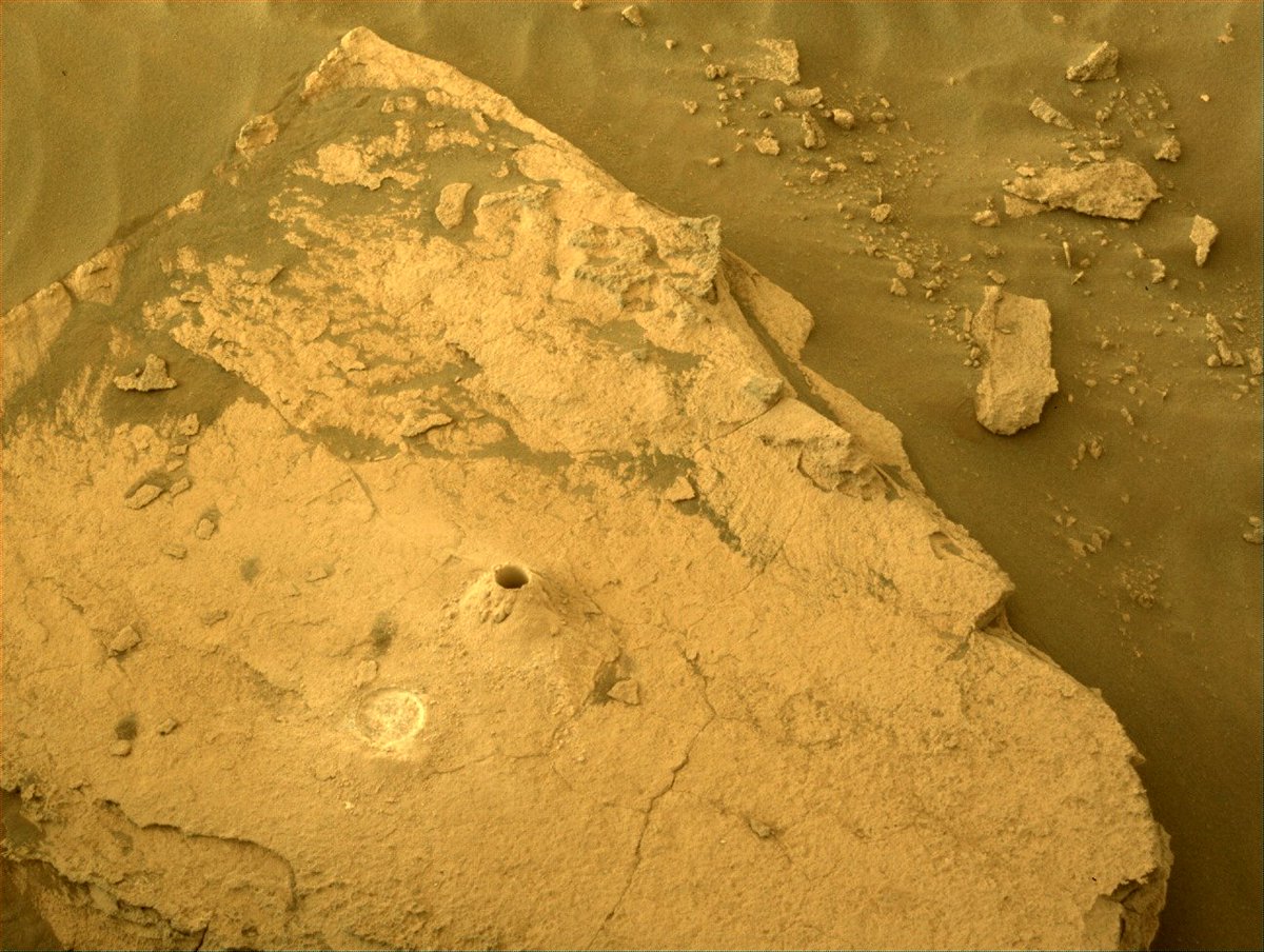 Un agujero que muestra dónde el rover Perseverance Mars excavó su novena muestra de roca marciana.