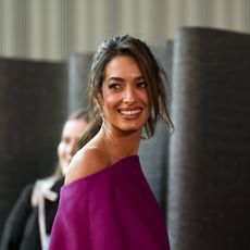 a paparazzi photo of a woman wearing a purple dress