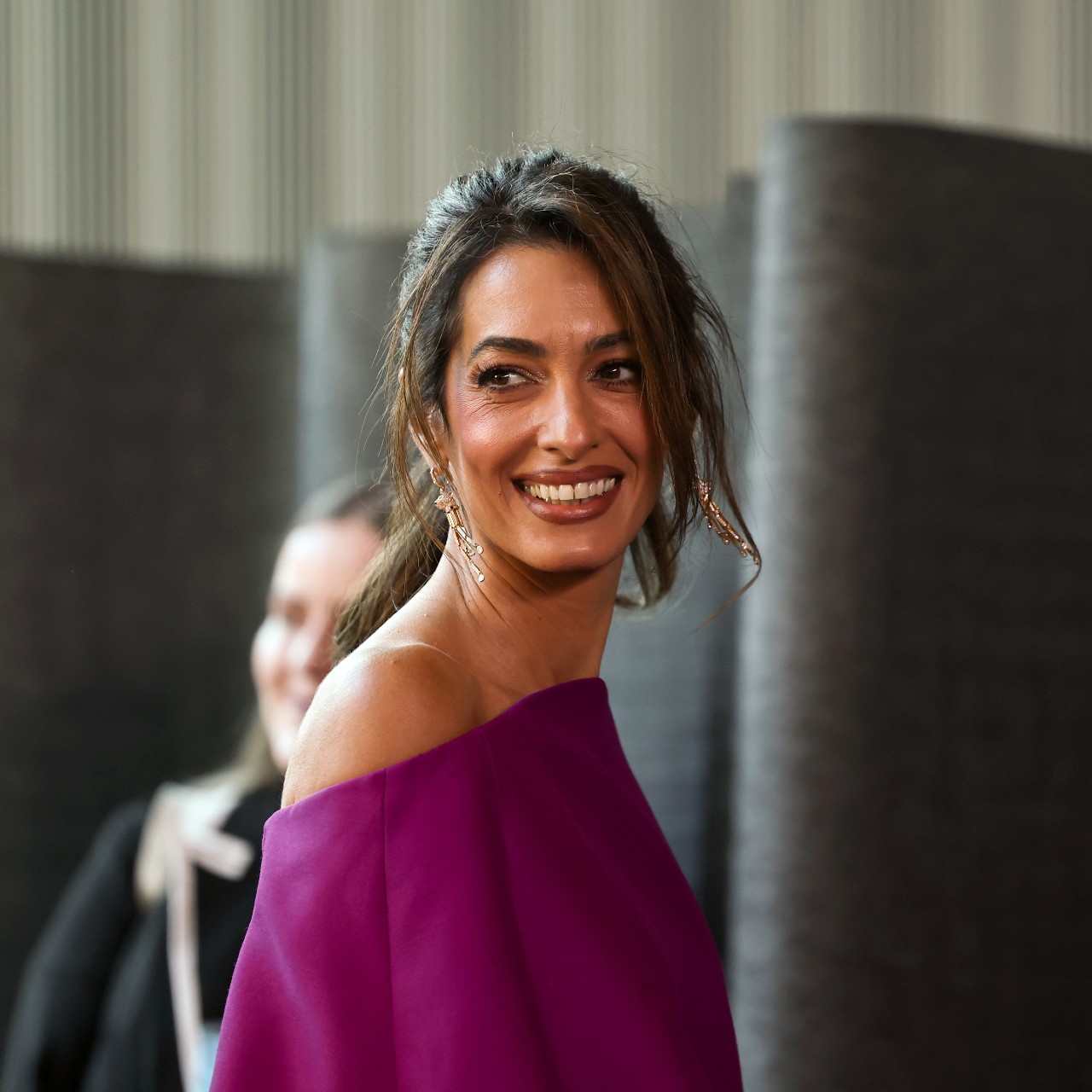 a paparazzi photo of a woman wearing a purple dress