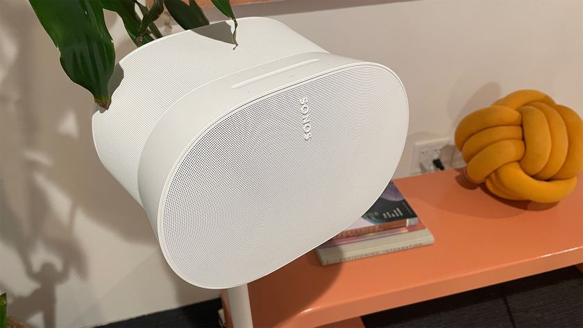 A white Sonos Era 300 speaker on its stand next to a wooden countertop.