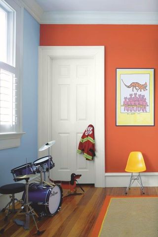 Children's room with blue and orange walls, yellow chair and drum kit