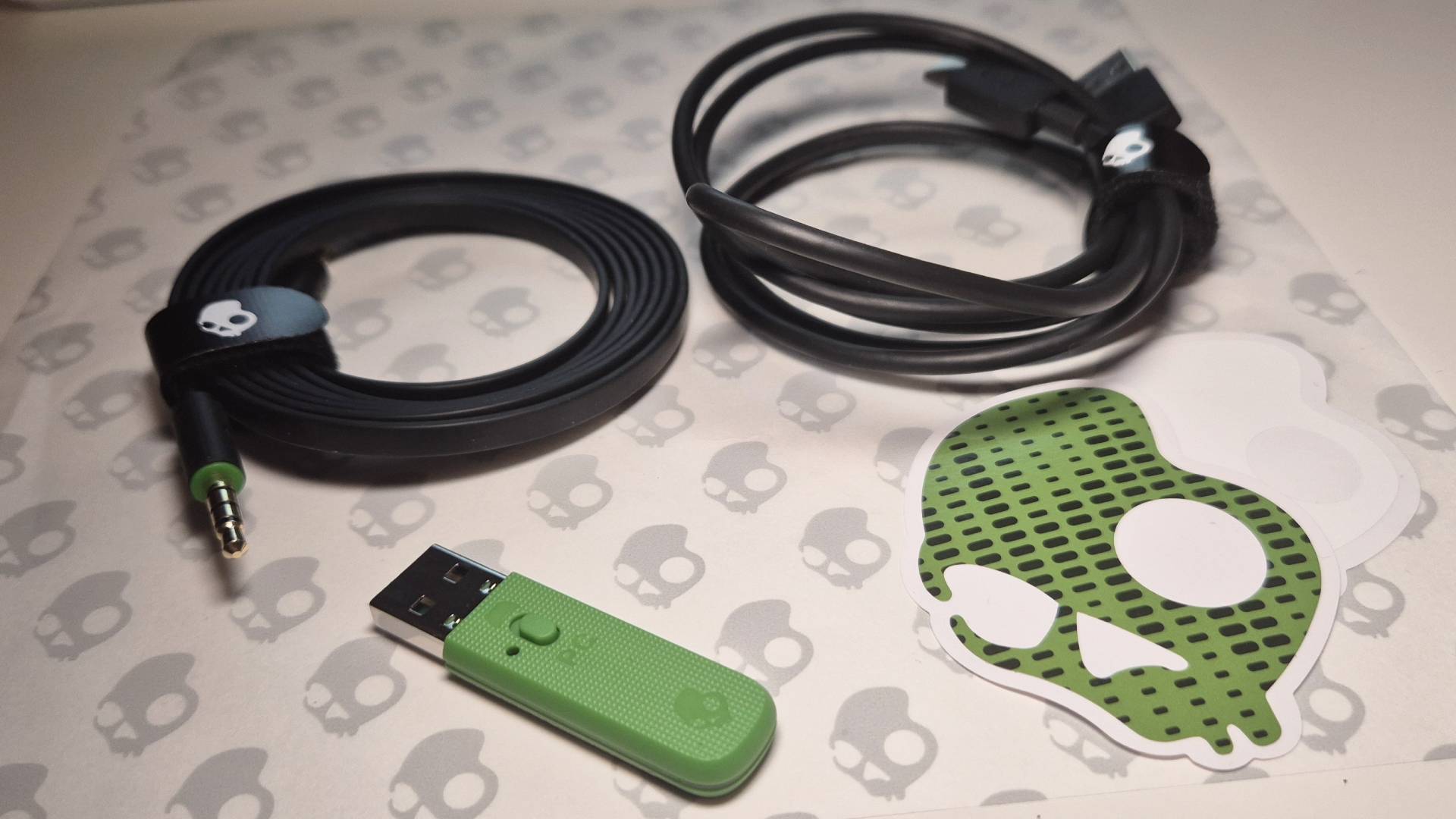 Photo of the wireless dongle and cables packaged with the Skullcandy Crusher PLYR 720 wireless gaming headset.