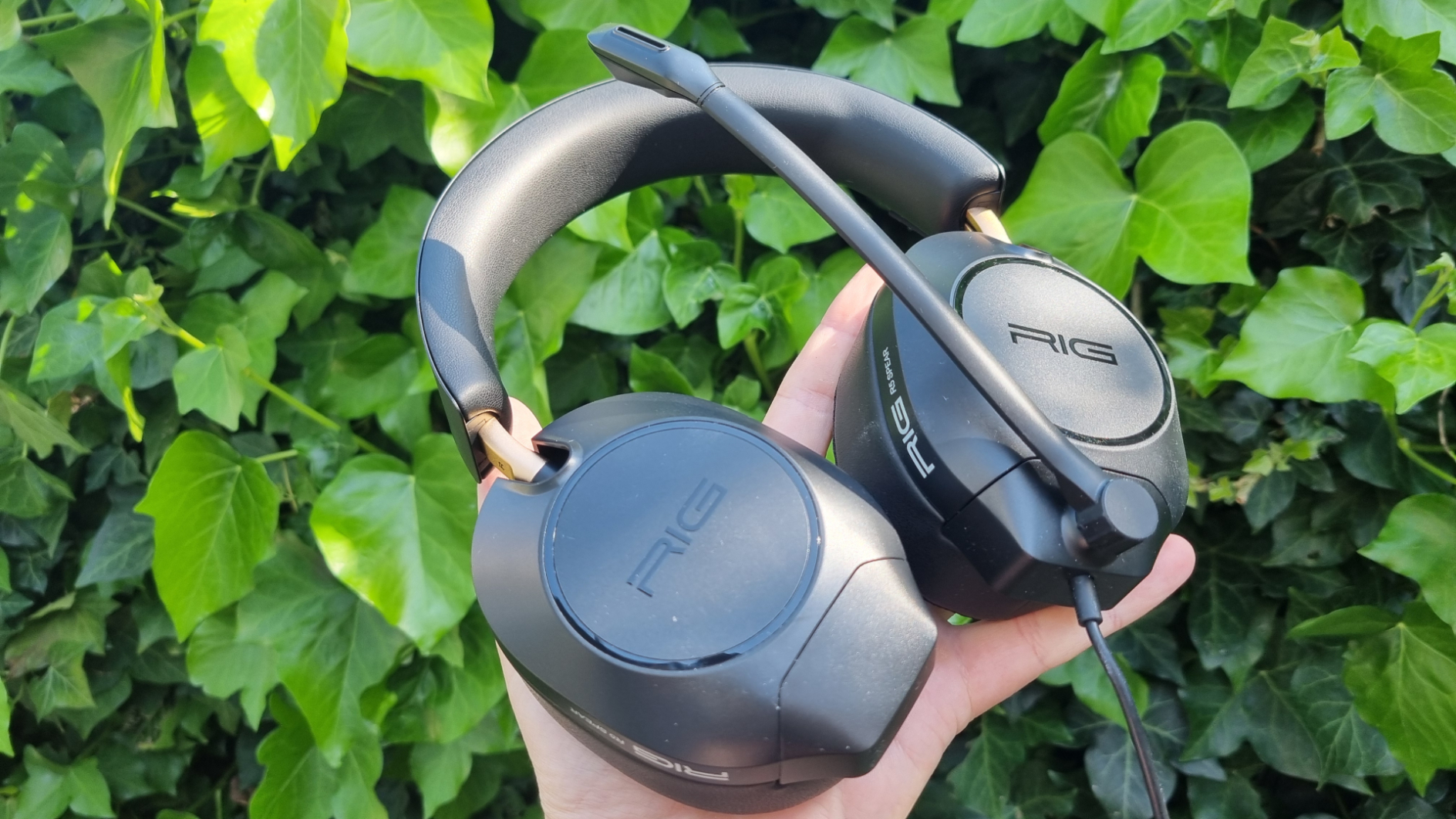 A Rig R5 Spear Max HD gaming headset in front of a hedge