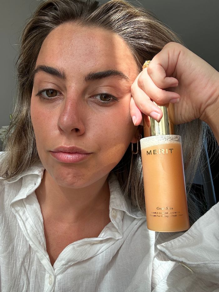 Shannon Lawlor after using Merit Great Skin Double Cleanse, while holding up a bottle