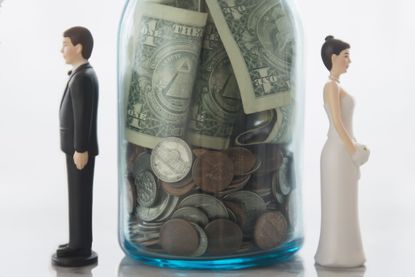 Bride and groom figures on either side of savings jar