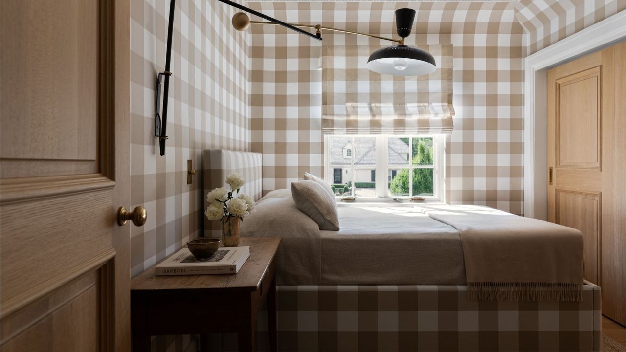 gingham pattern drenched bedroom with matching upholstered beige checked bed and wallpapered walls