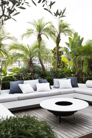 patio flooring made from decking in an urban tropical garden with palm trees