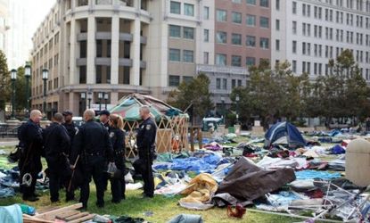 Oakland officers congregate in the remains of the Occupy Oakland camp after police shut it down Tuesday night.