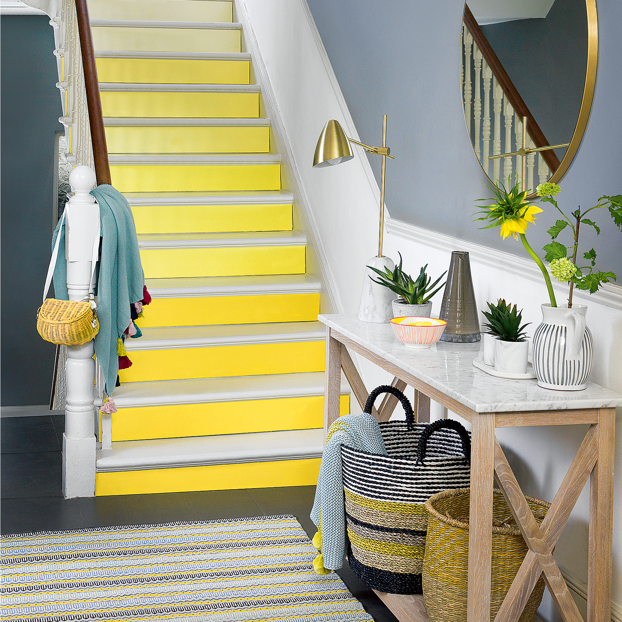 Blue hallway with yellow stairs and console table