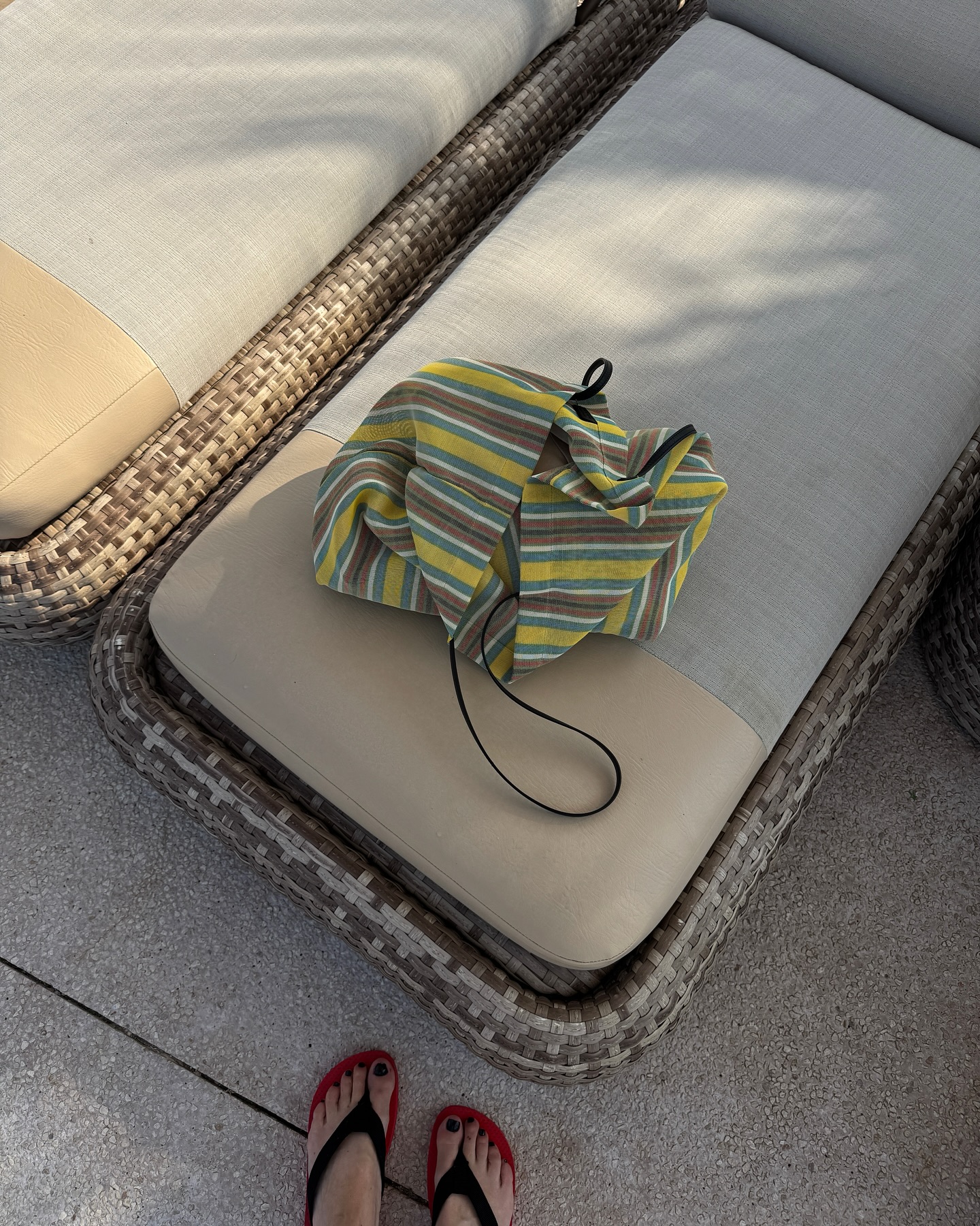 An image of @monikh wearing The Row's barn mesh tote bag with the brand's viral Dune flip-flops.