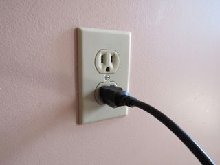US standard power outlet with cable hanging out of one socket