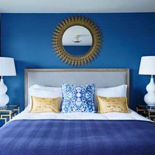 mirror above bed in a blue bedroom