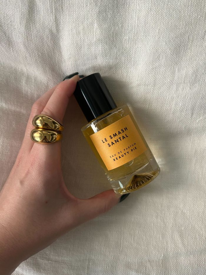 Junior beauty editor Grace Lindsay holding the Beauty Pie Le Smash Santal perfume