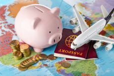 Travel money with piggybank, airplane and passport