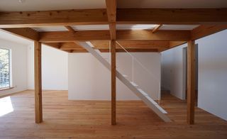 A minimalist staircase leads up to the first floor, which features a gabled roof and a dormer window, brining plenty of light and air into the home