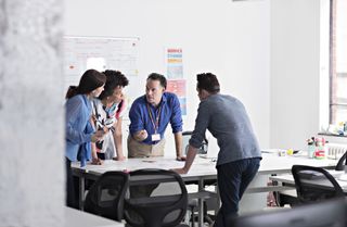 Colleagues discussing a business challenge around a table.