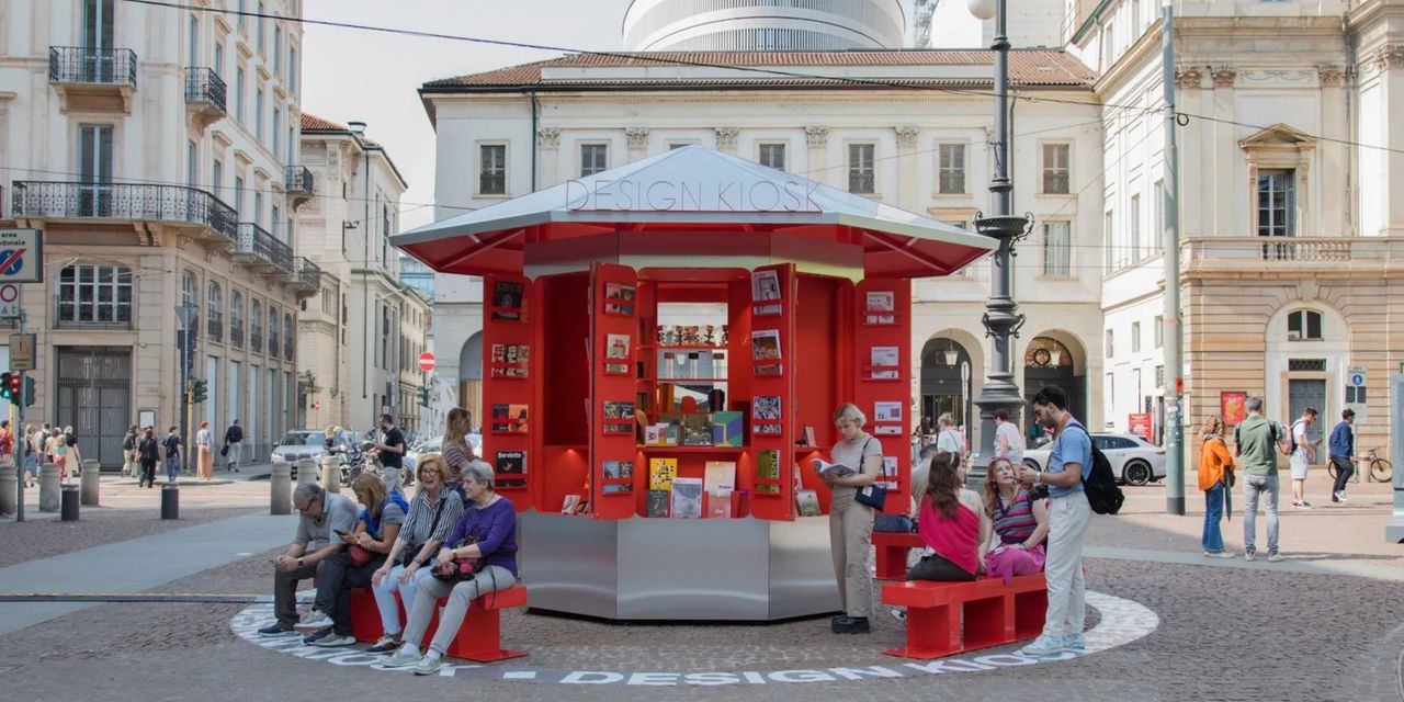 A design kiosk in a square surrounded by people