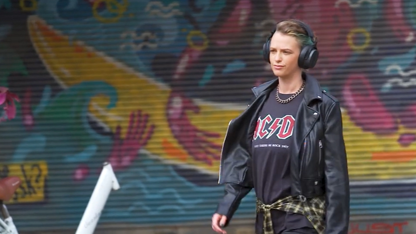 a woman wearing the heavys headphones while walking