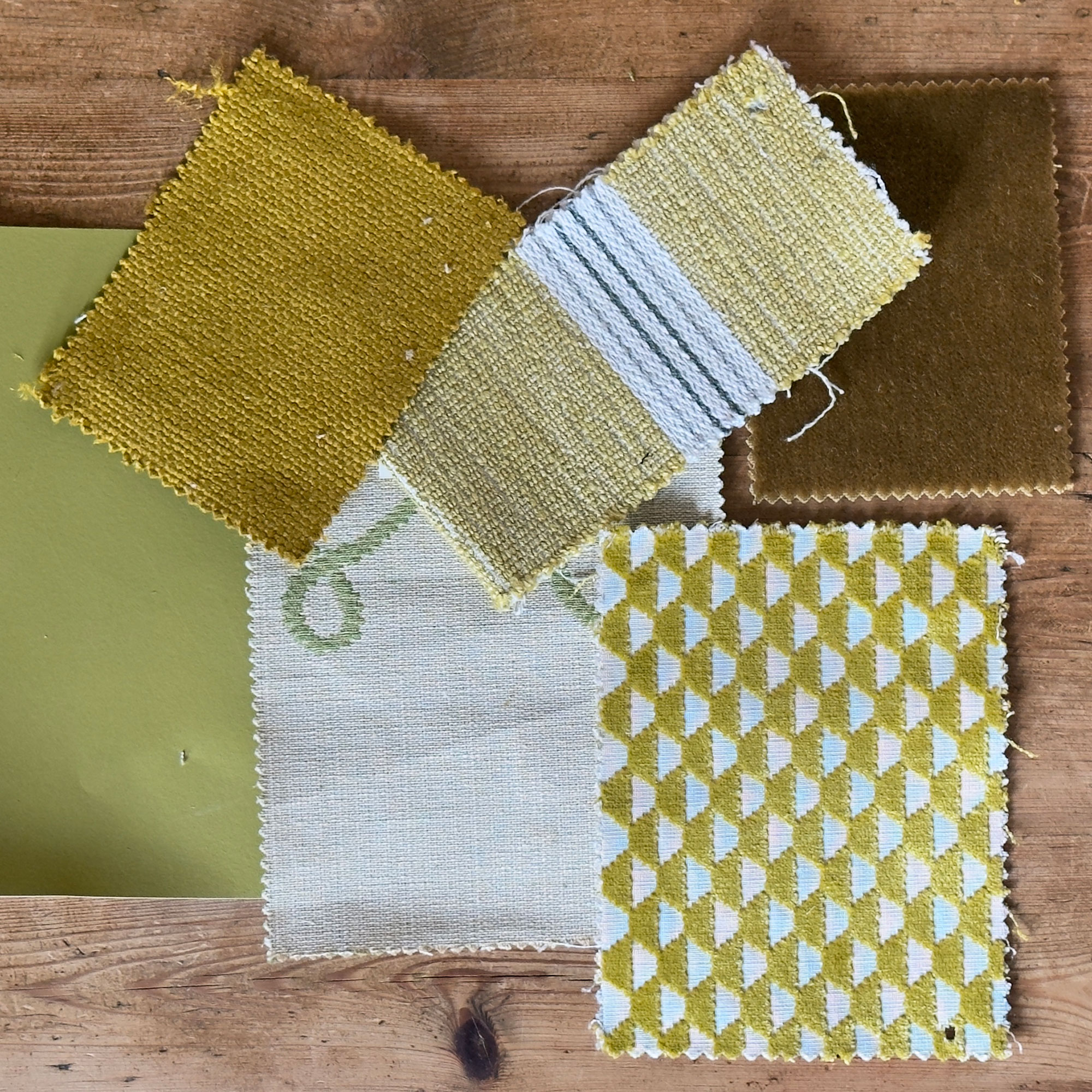 Selection of chartreuse fabric samples on wooden table