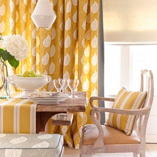 dining room with yellow curtains wooden table and chair