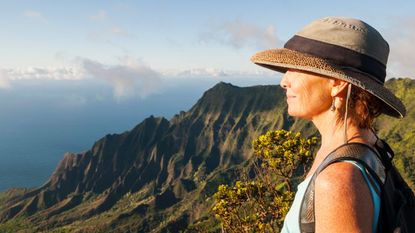 A woman enjoys a view while hiking.