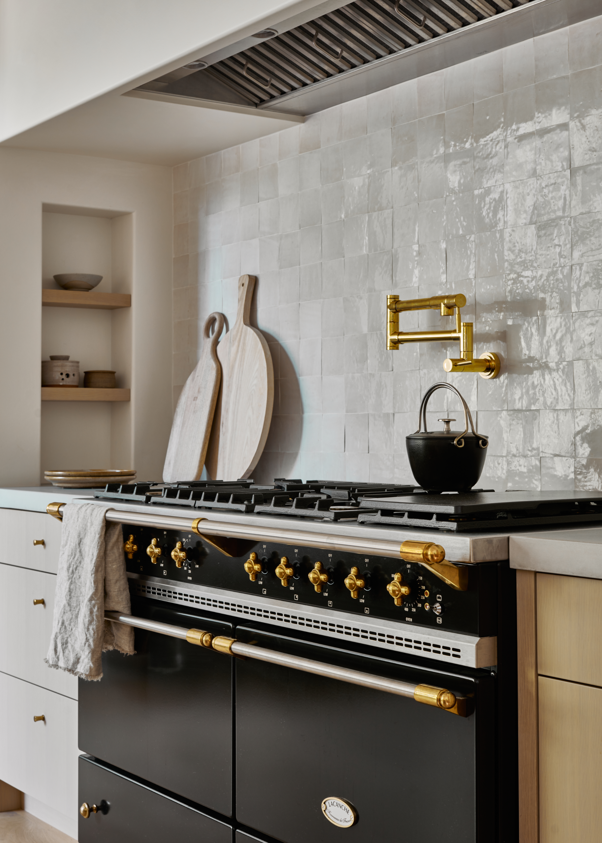 Californian kitchen style with zellige tile backsplash and a oven/stove with a pot on top of it.