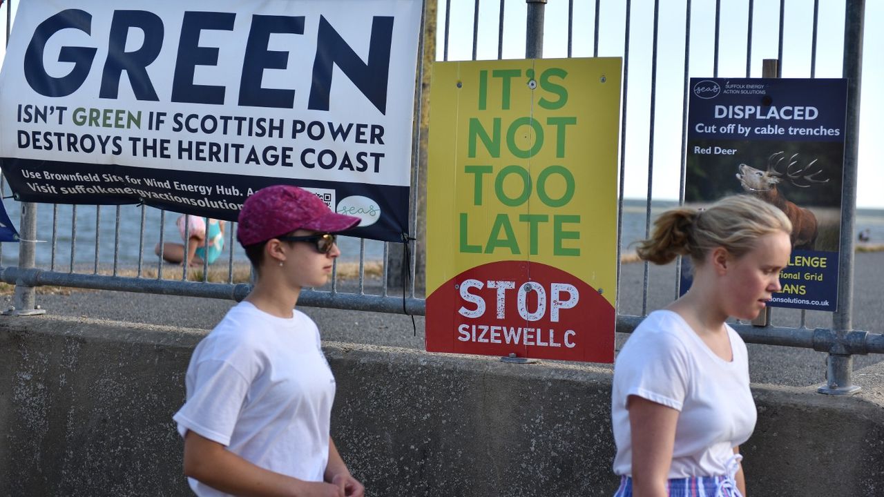 People walk past anti-Sizewell C placards 