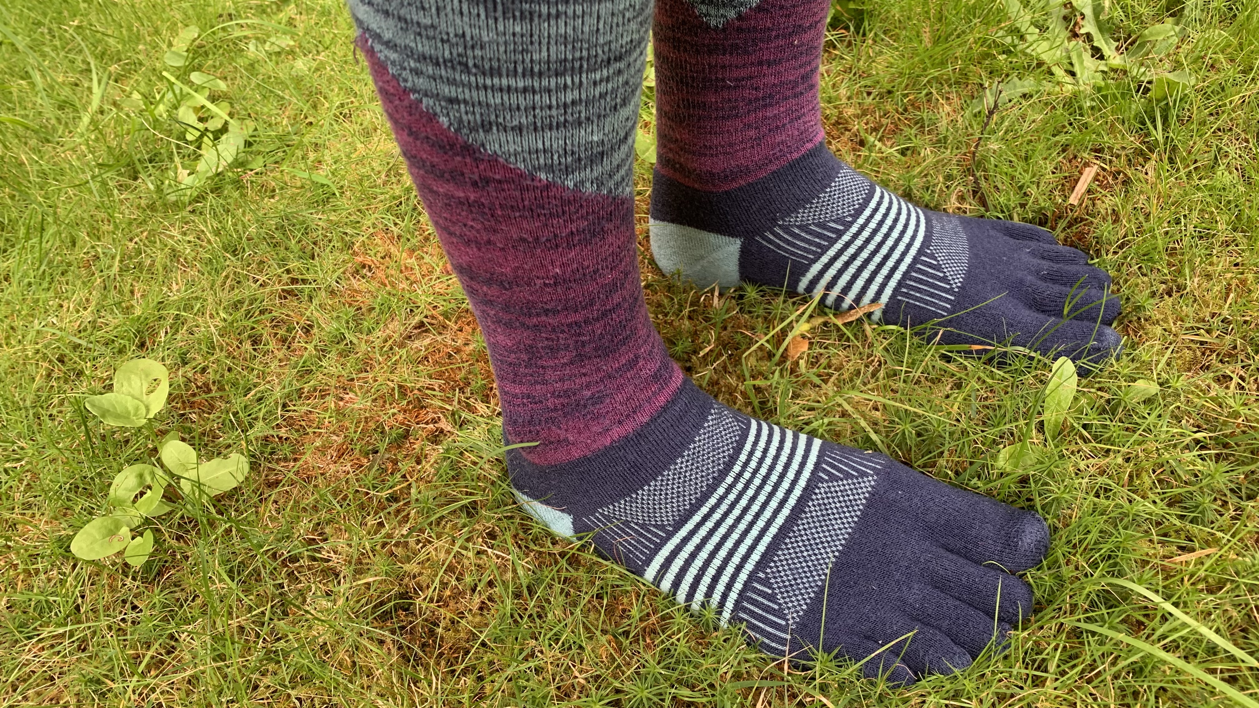 Feet standing in the grass wearing the Injinji Trail Midweight Crew toe socks