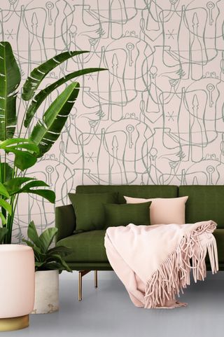 pink wallpaper with a green sofa
