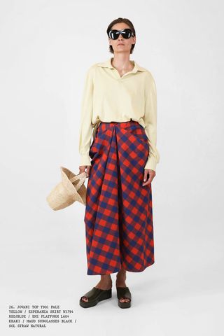 Woman in yellow top and plaid skirt from The Row