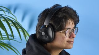 a pair of black bluetooth headphones made by OneOdio Focus A5 is photographed against a blue background