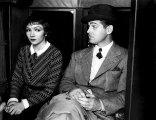 a couple stands next to each other in a tight elevator in the movie it happened one night