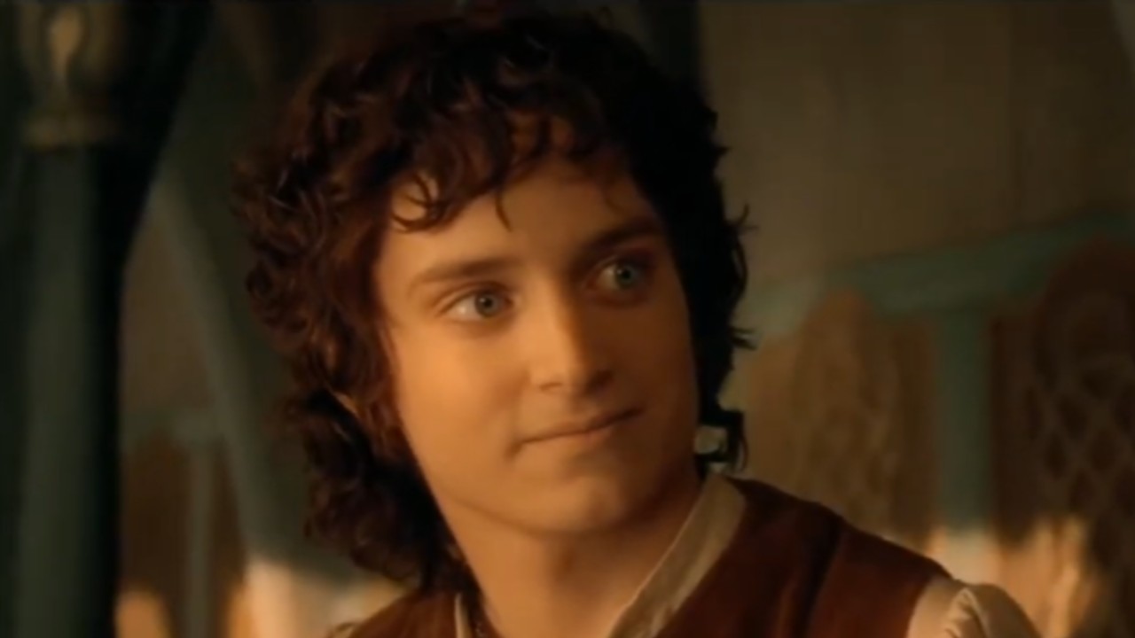 Frodo looking to his right and starting to smile in Lord of the Rings.
