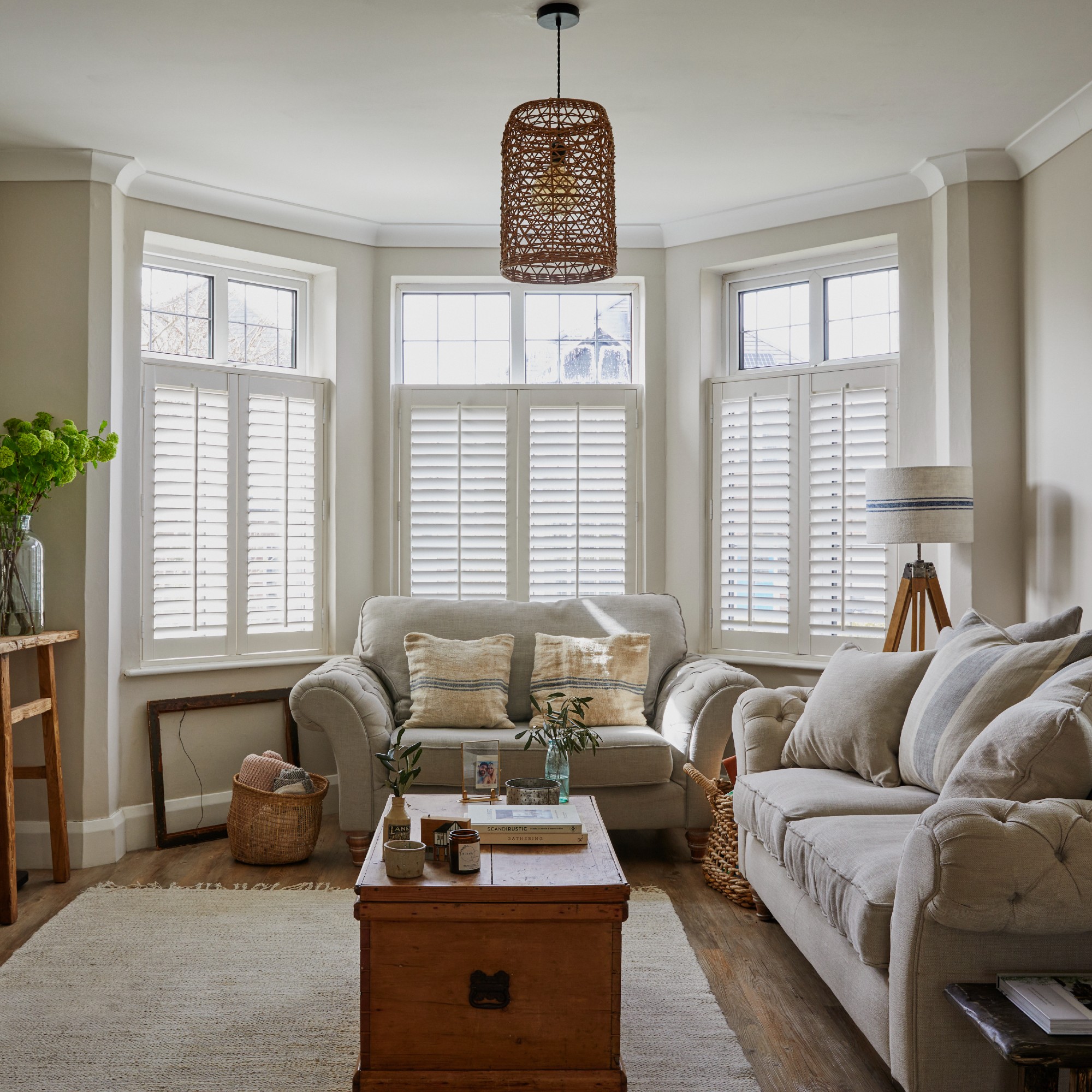 Cosy neutral living room with a chest coffee table and half height shutters on the bay window