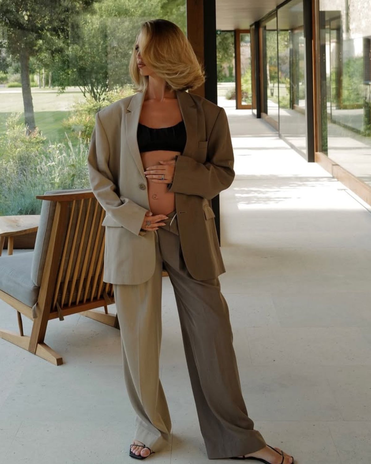 @saasha_burns wears hair in voluminous Monaco bob while wearing a crop top and trouser suit