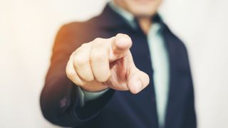 Business man pointing finger soft focus background