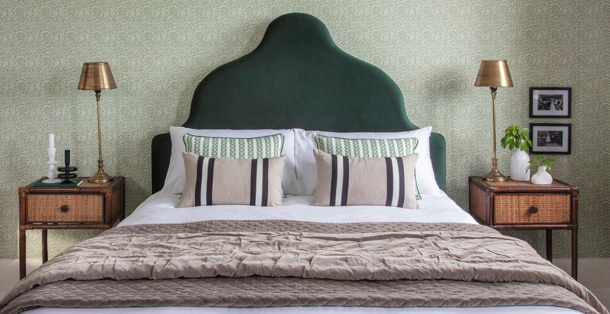 bedroom with green leaf wallpaper and green velvet headboard with matching bedside tables dressed with trinkets to show how to make your bedroom feel like a luxury hotel