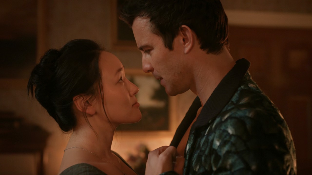 Sophie looking up at Benedict, they're holding each others' hands to their chests. 