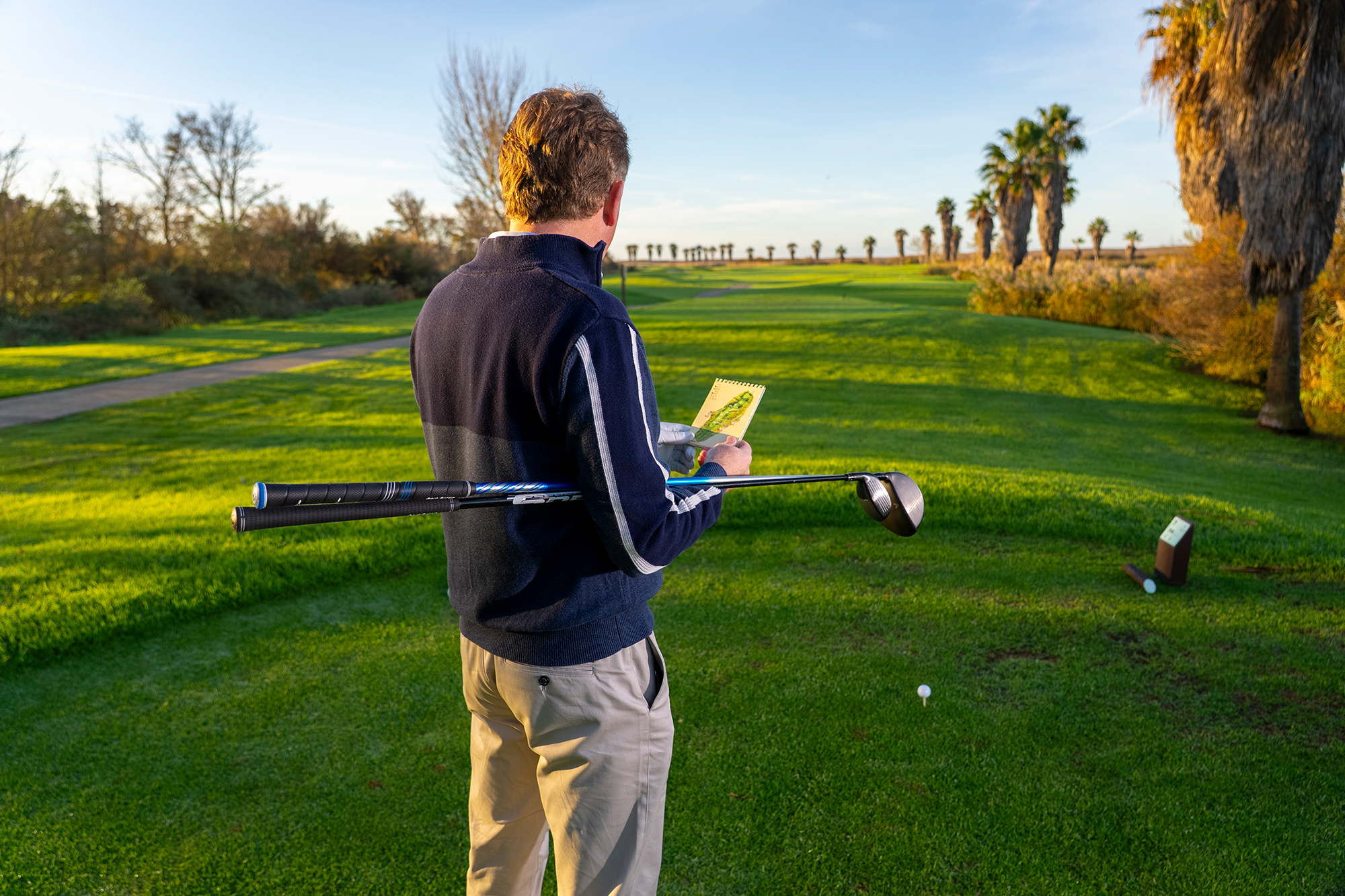 Keith Wood deliberating over whether to take a driver of or fairway wood off the tee, consulting his course guide