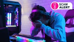 A man sitting in front of a PC with his head in his hands