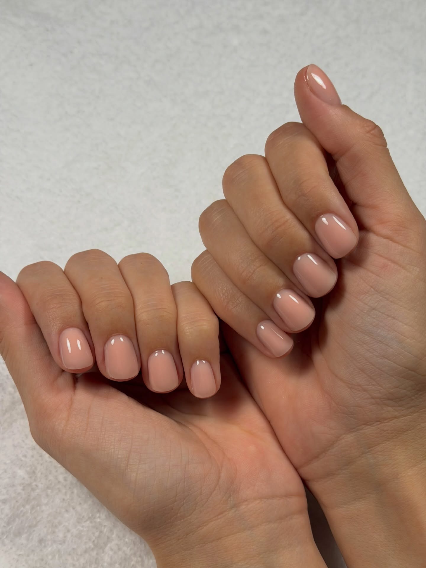 A glossy, sheer peach manicure