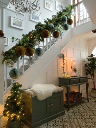 Christmas stair decor and garland with fairy lights in a Christmas hallway