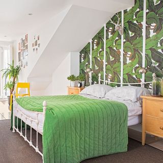 white walled bedroom with leafy wallpaper and carpet flooring