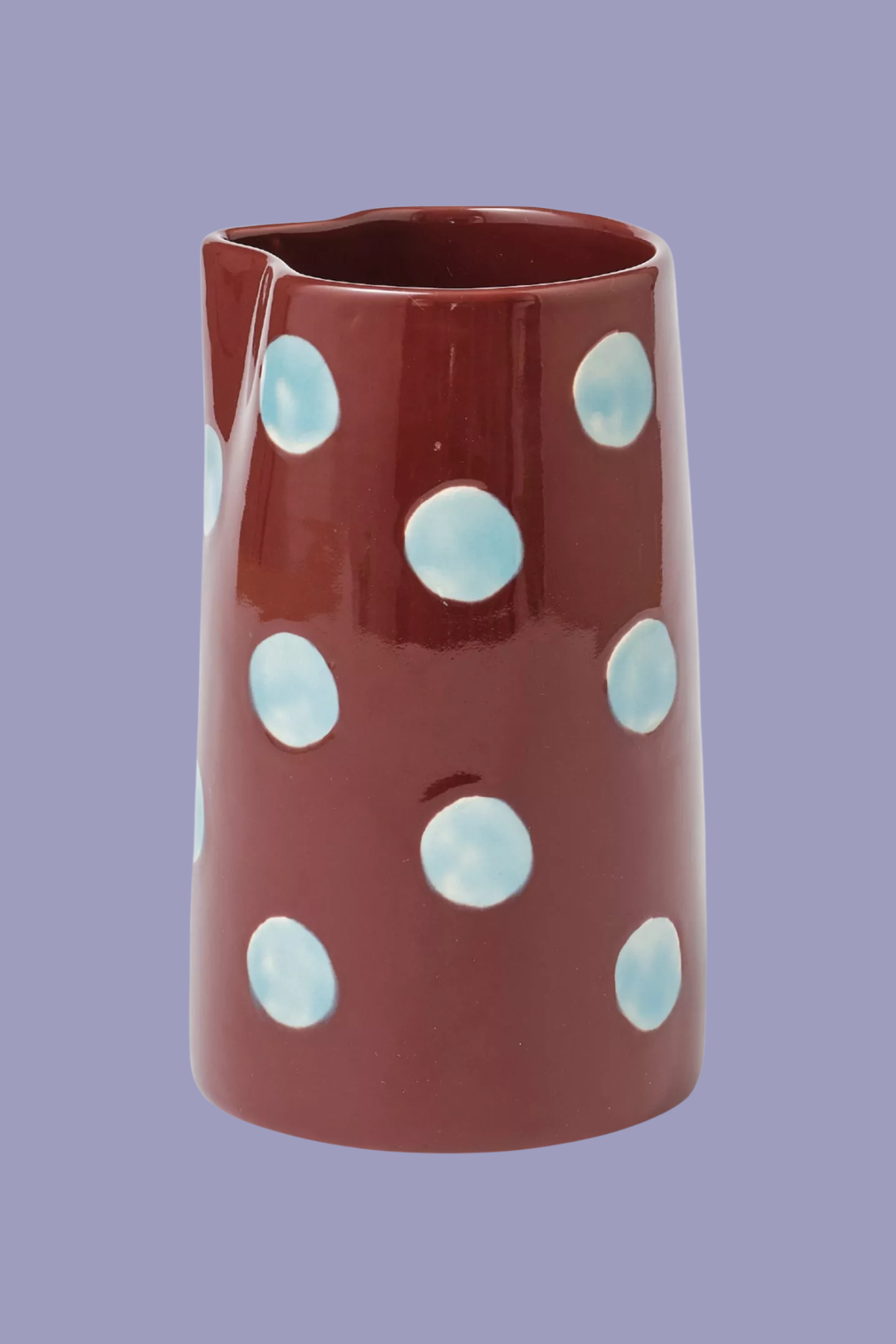 A burgundy brown jug with blue polka dots
